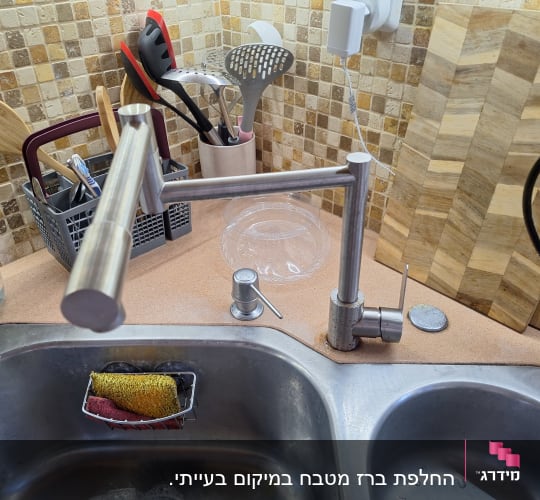 כיור מטבח עם ברז וכלי מטבח שונים